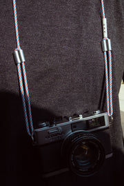 AME x Wolf Camera Strap in der Light Version an einer Kamera. AME x Wolf Camera Strap in der Light Version in verschiedenen Farben. Du finanziert 1 Monat Schule mit dem Kauf.